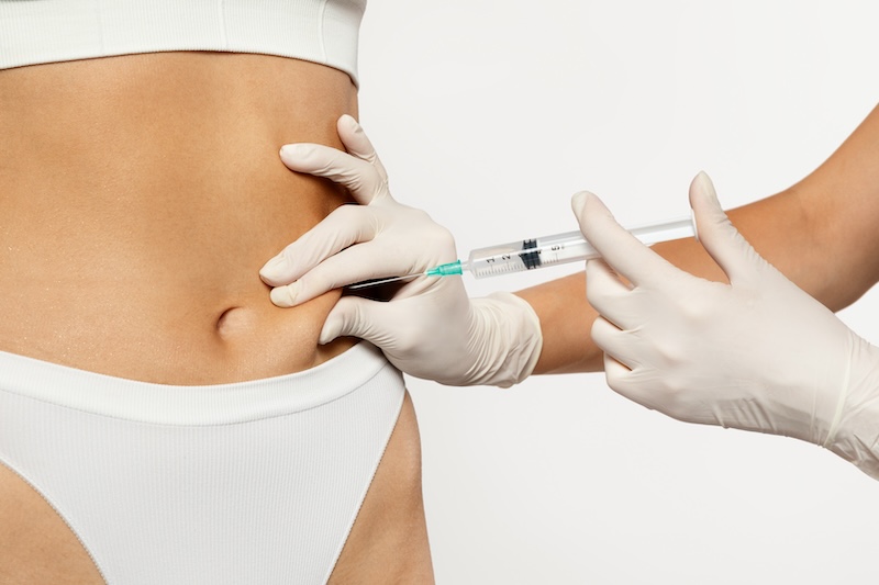 A gloved medical administering Mounjaro weight loss injection in abdomen